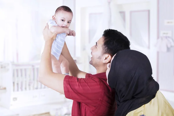 Parents lifting up their baby in bedroom — Stock Photo, Image