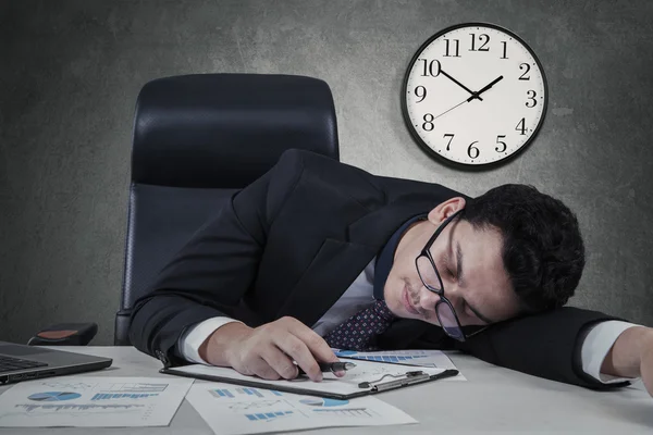 Manager slapen met de klok op de muur — Stockfoto
