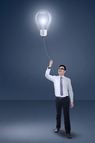 Мужчина-предприниматель тянет лампу — стоковое фото
