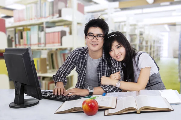 Adoráveis dois estudantes na biblioteca — Fotografia de Stock