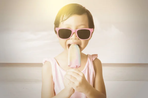 Criança alegre come sorvete na costa — Fotografia de Stock