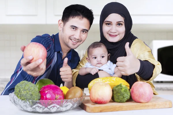 Keluarga sehat menunjukkan jempol-up di dapur — Stok Foto