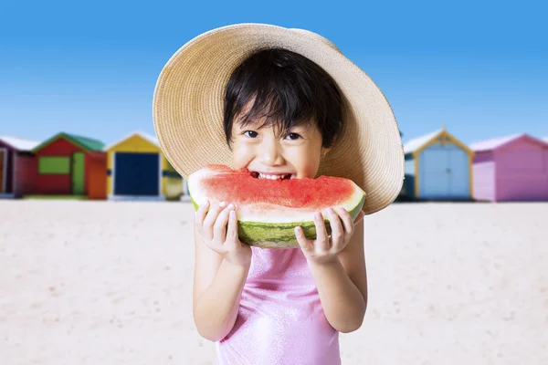 Criança feliz morde uma melancia — Fotografia de Stock