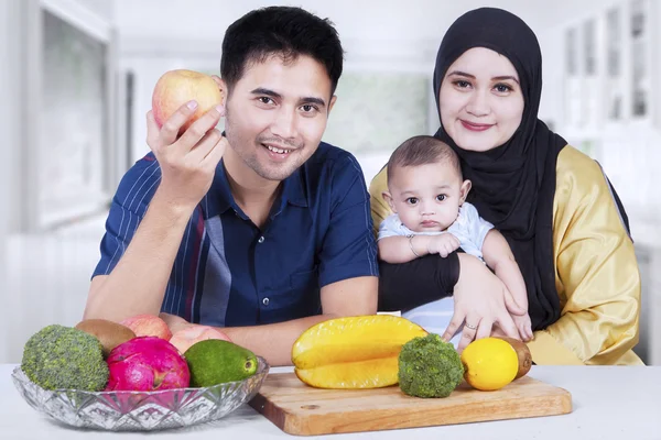 Gelukkige familie met vers fruit thuis — Stockfoto