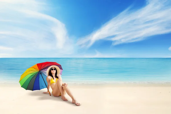 Turismo femminile seduta sotto l'ombrello — Foto Stock