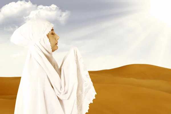 Female muslim in white praying at desert — Stock Photo, Image