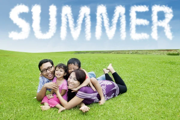 Asian parents lay at field with their children — Stock Photo, Image