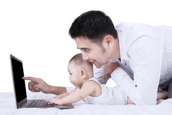 Menino usando laptop com seu pai — Fotografia de Stock