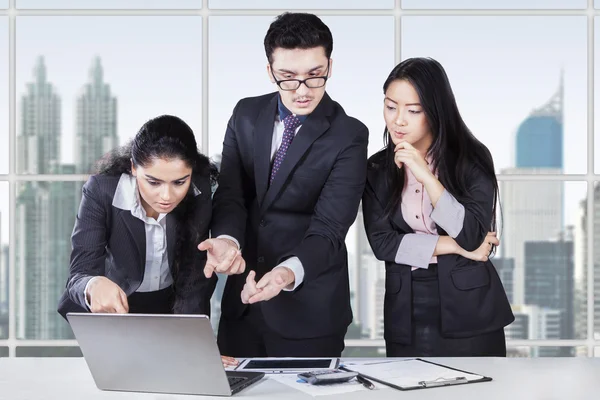 Business-Team diskutiert mit Laptop — Stockfoto