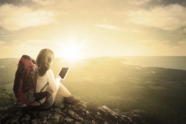 Female hiker using tablet at mountain — Stock Photo, Image