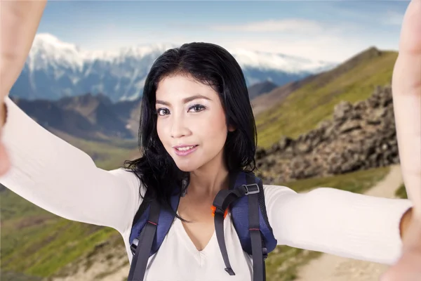 Turysta biorąc selfie zdjęcie na zboczu góry — Zdjęcie stockowe