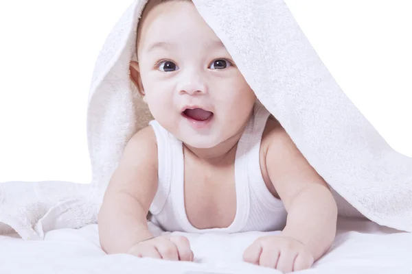 Niño sonriendo a la cámara en la cama — Foto de Stock