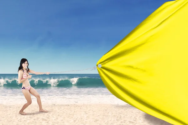 Vrouw sleept lege banner aan de kust — Stockfoto