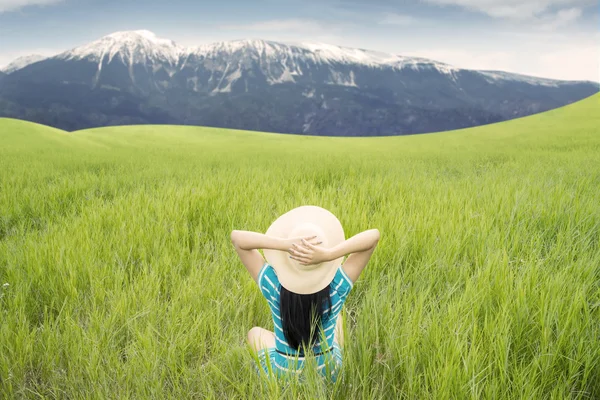 Mujer disfrutando de la vista a la montaña en el prado —  Fotos de Stock