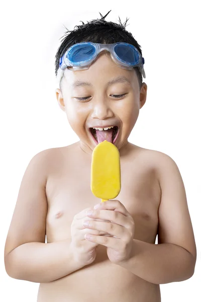 Garoto alegre desfrutando de sorvete no estúdio — Fotografia de Stock