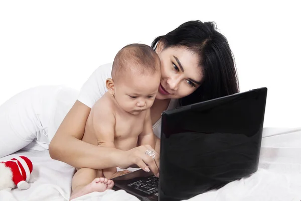 Mamma och barn med laptop på sängen — Stockfoto