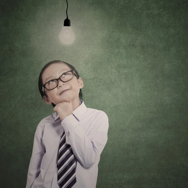 Smart little businessman under lit bulb — Stock Photo, Image