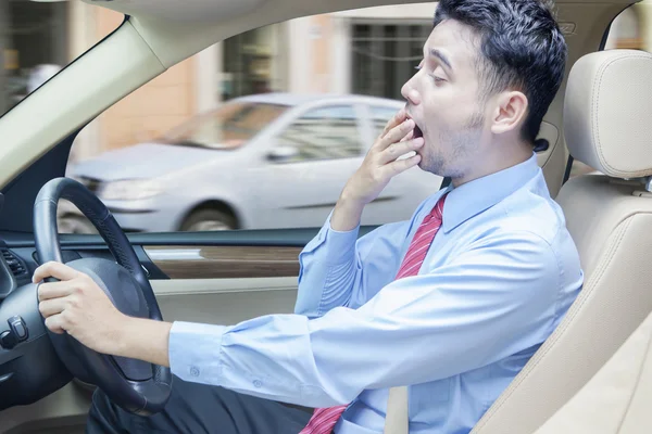 Hombre cansado conduciendo un coche — Foto de Stock