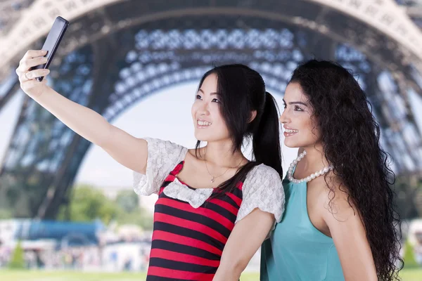 Two girls taking photos at Eiffel Tower — Stock Photo, Image