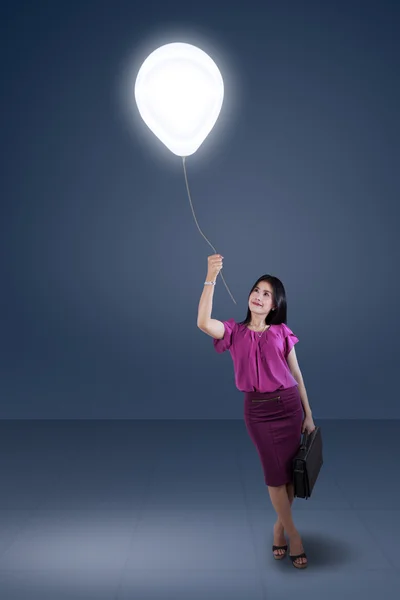 Woman pulling a bright balloon — Stock Photo, Image