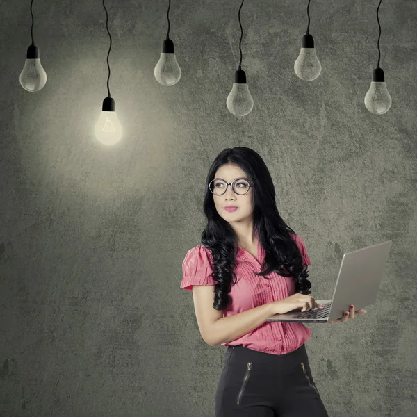Arbetstagare med laptop tittar på lampa — Stockfoto
