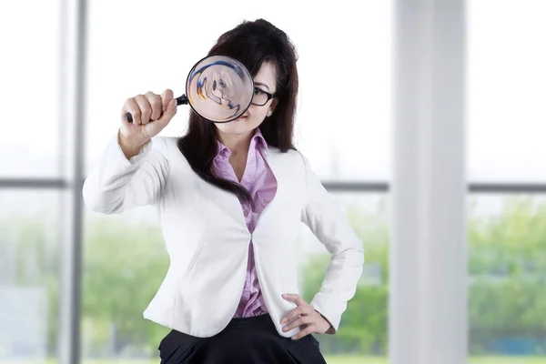 Werknemer met vergrootglas in de buurt van het venster — Stockfoto