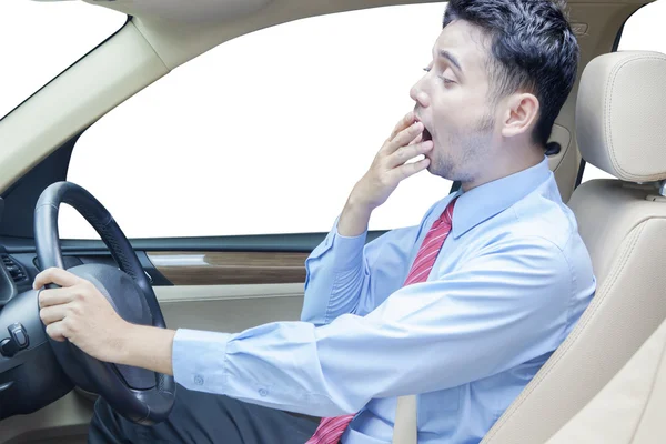 Молодой человек зевает в машине — стоковое фото
