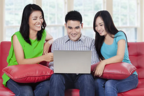 Ungdomar med laptop sitter på soffan — Stockfoto