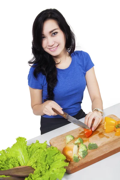 Hermosa mujer preparando ensalada en la mesa — Foto de Stock