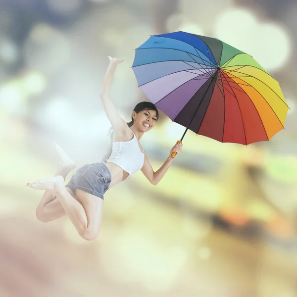 Woman jumps over light glitter background — Stock Photo, Image