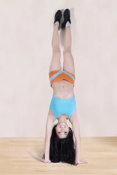 Mujer haciendo handstand por lean en pared — Foto de Stock