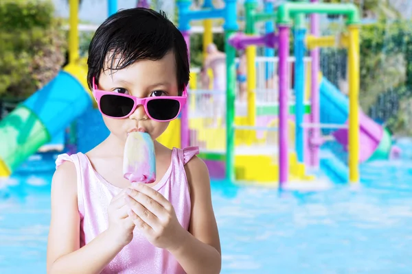 Petite fille mordre la crème glacée à la piscine — Photo