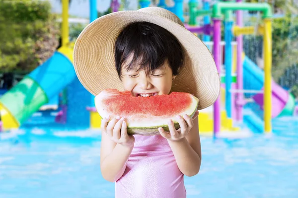 Menina morde melancia na piscina — Fotografia de Stock