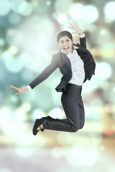 Businesswoman leaps with bokeh background — Stock Photo, Image