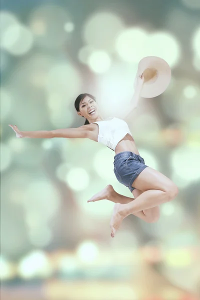 Casual woman jumps with bokeh background — Stock Photo, Image