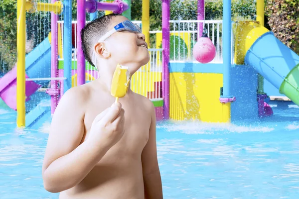 Criança com um saboroso sorvete na piscina — Fotografia de Stock