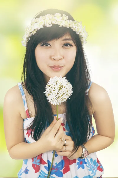 Girl blowing flower with bokeh background — Stock Photo, Image