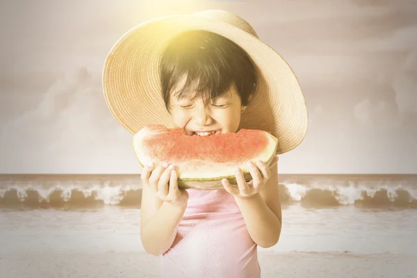 Menina desfrutar de uma melancia na costa — Fotografia de Stock