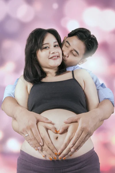 Femme enceinte avec mari et symbole du cœur — Photo