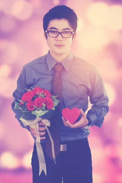 Romantisk person innehar blomma med defocused lampor — Stockfoto
