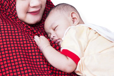Annenin göğsünde uyuyan sevimli bebek