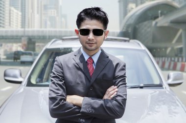 Arabanın önünde duran başarılı kişi