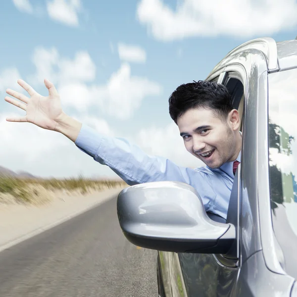 Joyeux homme agitant la main dans la voiture — Photo