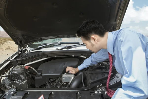 Mężczyzna kontroli maszyny uszkodzonego samochodu — Zdjęcie stockowe