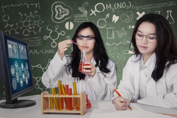 Dois estudantes bonitos que trabalham no laboratório — Fotografia de Stock