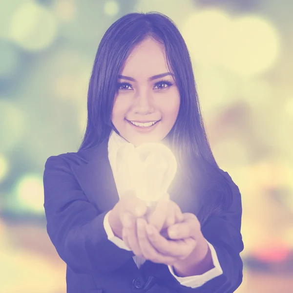 Woman with light bulb and blur background — Stock Photo, Image