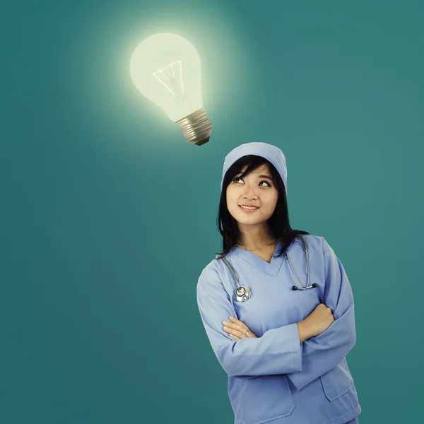 Young female surgeon with light bulb — Stock Photo, Image