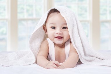 yatakta havlu altında heyecanlı bebek oğlan