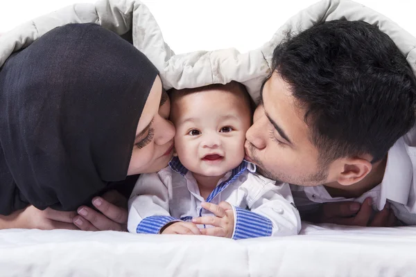 Привлекательный ребенок под одеялом с родителями — стоковое фото