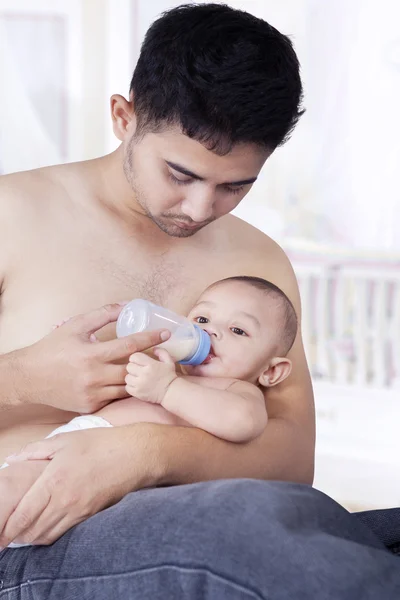 Baby drinking milk with dad in bedroom — Stock Photo, Image